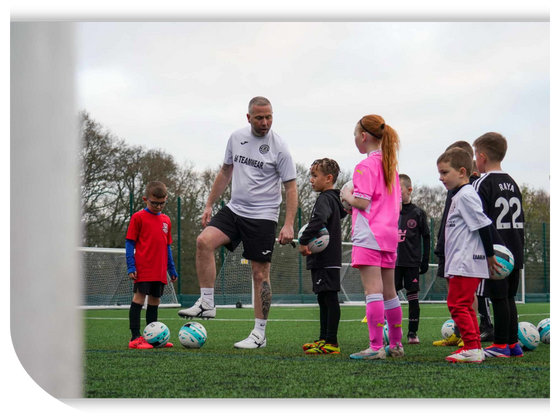 Young football players at GS Coaching Academy wearing team jerseys on a football field